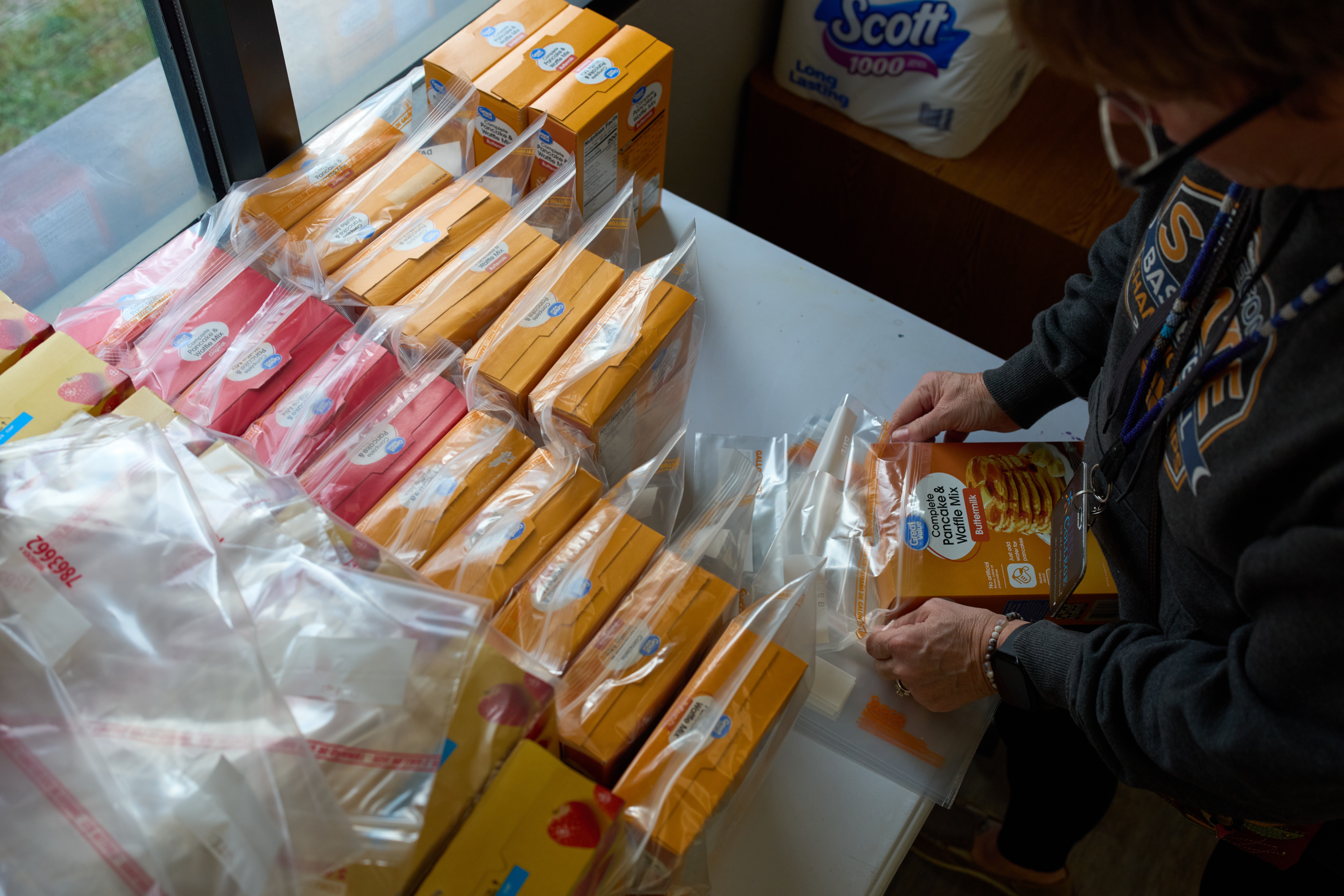 Jen Janecek Hartman helps prepare bagged meals for a food bank for students at Nueta Hidatsa Sahnish College on Oct. 30 in New Town, N.D.